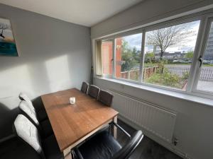 曼彻斯特Cosy 2-Bed House in Ancoats Manchester!的一间带桌椅和窗户的用餐室