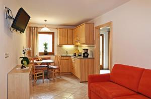 萨伦蒂诺Ferienhaus Berger的一间带红色沙发的客厅和一间厨房