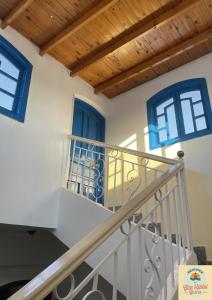 卢克索Gîte Hôtel Gezira Louxor 2的房屋内的楼梯,设有蓝色的窗户