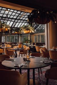 布吕门Kasteel Engelenburg的餐厅设有桌椅和玻璃天花板