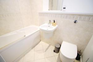 卡迪夫Quaysideone bedroom apartment in Cardiff Bay的浴室配有卫生间、盥洗盆和浴缸。