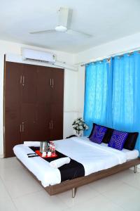 浦那Hotel Pristine,Pune的一间卧室配有一张带蓝色窗帘的大床
