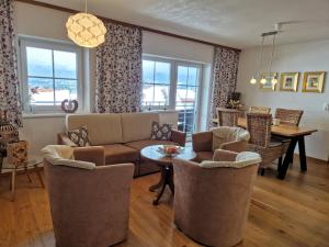 罗伊特Alpenhof Wängle的客厅配有沙发、椅子和桌子