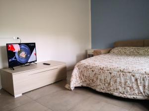 贝加莫Bergamo Centro Residence的一间卧室配有一张床,梳妆台上配有电视