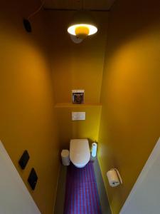 菲希塔赫Adventure Camp Schnitzmühle的浴室设有白色卫生间和黄色墙壁。