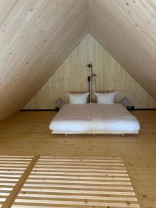 菲希塔赫Adventure Camp Schnitzmühle的阁楼上的白色床,屋顶