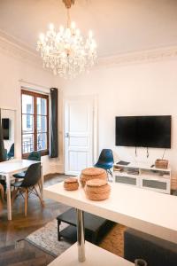 斯特拉斯堡Les Appartements Rue des Veaux - Quartier Cathédrale的客厅配有桌子和吊灯