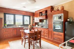 莱萨马Karaltzos LB00530的厨房配有木制橱柜和桌椅