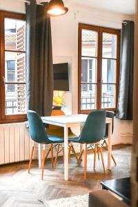 斯特拉斯堡Les Appartements Rue des Veaux - Quartier Cathédrale的一间带桌子和两把椅子的用餐室