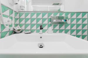 马奥莱米拉马雷酒店的浴室设有白色水槽和绿色及白色瓷砖