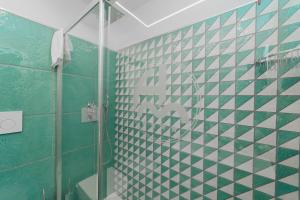 马奥莱米拉马雷酒店的浴室拥有绿色和白色的瓷砖墙