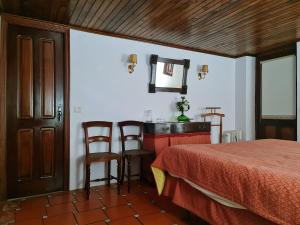 Quinta da Mochada的卧室配有一张床和一张桌子及椅子