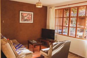 乌鲁班巴Kutimuy Lodge的带沙发和电视的客厅