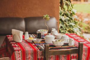 乌鲁班巴Kutimuy Lodge的一张桌子,上面有红色的桌布,上面有碗和杯子