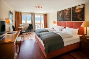圣沃尔夫冈兰德豪斯祖阿佩巴奇酒店的酒店客房设有一张大床和一张书桌。