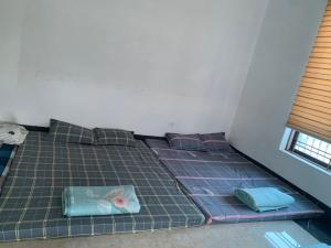 奠边府市502 Sân Bay Điện Biên的一张位于房间的床,上面有三个枕头