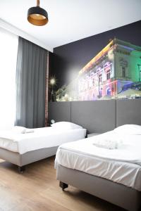 罗兹ADLER Bed&Breakfast的一间设有两张床的房间和一座带灯光的建筑