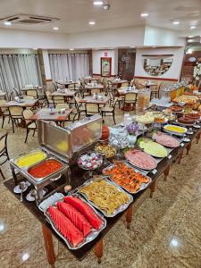 圣保罗Hotel Dan Inn Planalto São Paulo的长桌,长桌里放着不同种类的食物