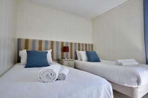 贝克因顿Farleigh Lodge的白色客房的两张床,配有蓝色枕头