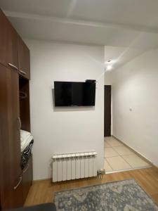 贝尔格莱德Apartments & Rooms L E F T RIVER Belgrade的一间客厅,在白色的墙上配有电视