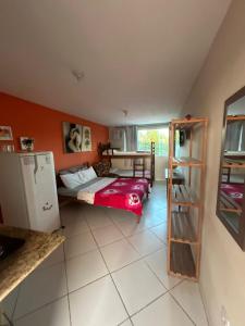 布希奥斯Flats vila bela Búzios的小房间设有一张床和一台冰箱