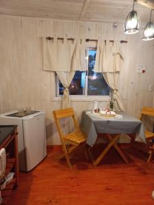 乌里韦拉雷亚SanDo Uribe Cabañas Exclusivas solo adultos的厨房配有桌椅和窗户。