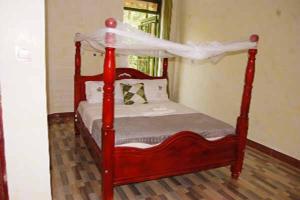 LukunyuLoginecoresort的客房内一张红色的床和天蓬