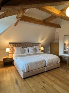 罗蒙La Belle-Croix的卧室配有一张白色大床,铺有木地板