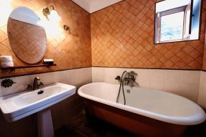 GuarazocaFinca La Sabina的带浴缸、水槽和镜子的浴室