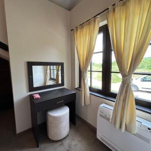 BalaleyaГеша Хил Парк СН21的客房设有电视和带窗帘的窗户。