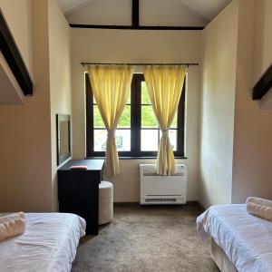 BalaleyaГеша Хил Парк СН21的一间卧室设有两张床和窗户。