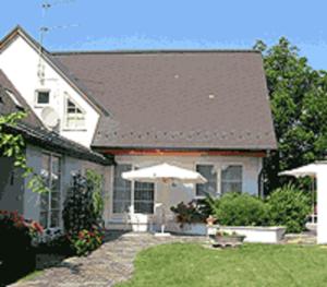 MitterretzbachWeinlandhaus的院子里的白色房子,带雨伞