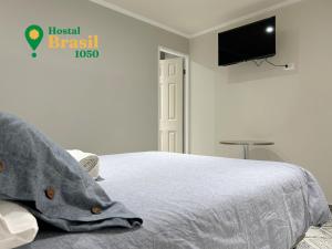 拉塞雷纳Hostal Brasil 1050的一间卧室配有一张床和一台平面电视