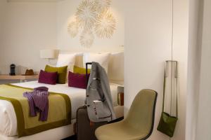 巴塞尔帕萨基 - 城市休闲酒店的一间卧室配有一张床和一把椅子