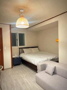 首尔Jnineguesthouse的一间卧室配有一张大床和一张沙发
