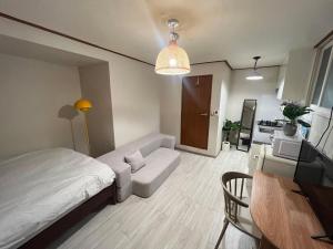 首尔Jnineguesthouse的小房间设有一张床和一张桌子