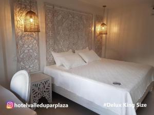巴耶杜帕尔Hotel Valledupar Plaza的一间卧室配有一张带白色床罩的大床