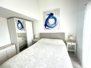 乌马格玛丽亚公寓式酒店的白色卧室配有床和镜子