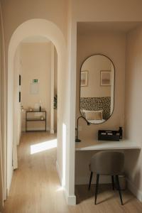 巴达霍斯Apartamentos Cervantes的走廊上设有镜子和椅子