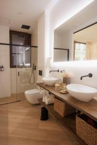 巴达霍斯Apartamentos Cervantes的浴室设有2个水槽、镜子和淋浴