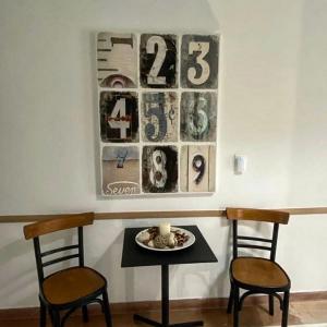 卡梅纳维洛拉Thalia Hotel的一张桌子、两把椅子和墙上的时钟