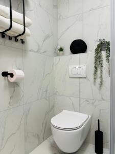 波尔托罗Luxury apartment magical Portorose的白色的浴室设有卫生间和一些植物