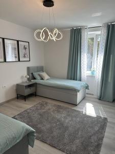 波尔托罗Luxury apartment magical Portorose的一间卧室配有两张床和吊灯。