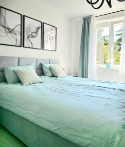 波尔托罗Luxury apartment magical Portorose的白色卧室配有一张带蓝色床单的大床