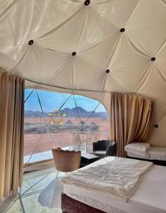 瓦迪拉姆RUM SUNRlSE LUXURY CAMP的一间带沙发床的卧室,享有沙漠美景