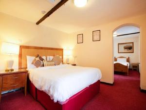 维斯贝希The Rose And Crown Hotel的一间卧室配有一张大床,铺有红地毯