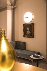 古比奥博索尼宫殿酒店的客厅配有沙发和墙上的绘画