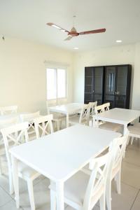 杜蒂戈林Mayilveedu Guest House的用餐室配有白色的桌子和白色的椅子