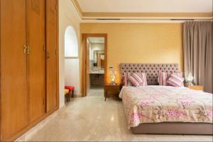 马拉喀什Maison 3 chambres的一间卧室配有一张带粉红色床罩的床