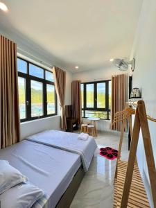 永熙Hotel Vũng Găng的卧室配有床、桌子和窗户。